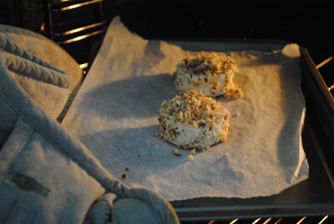Putting cobnut covered goats cheese in the oven